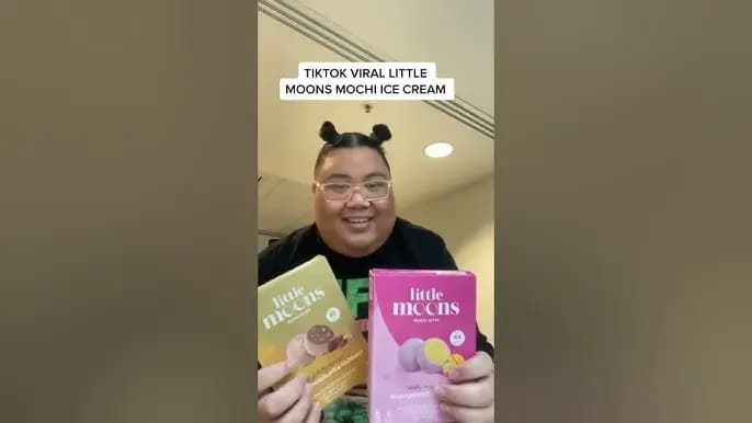Screenshot from a TikTok by Little Moons Mochi of a person holding up two packages of the product.