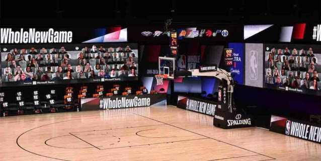 An image shows what the arenas will look like as the NBA National Basketball Association returns to play without fans. Large video monitors with fans and slogans are apparent around the court.